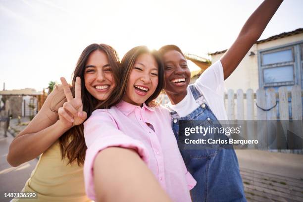 three multirracial female girls taking a selfie during holidays. - asian friends gathering stock pictures, royalty-free photos & images