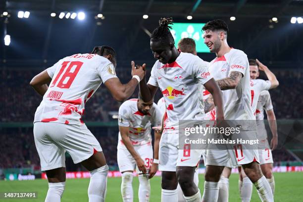 Christopher Nkunku of RB Leipzig celebrates with teammate Amadou Haidara after scoring the team's fourth goal during the DFB Cup semifinal match...