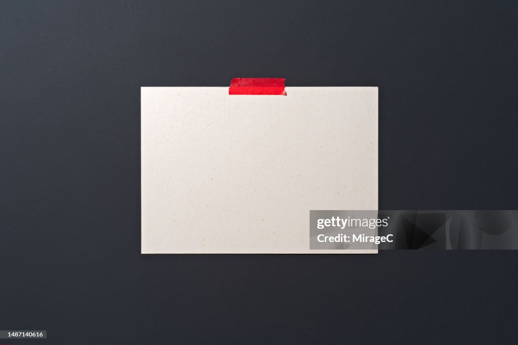 Blank Note Sticked With Red Adhesive Tape on Black Board