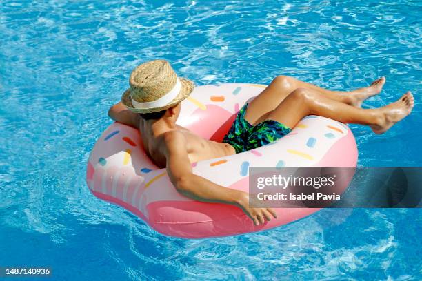 hispanic boy relaxed on inflatable ring - trögflytande bildbanksfoton och bilder