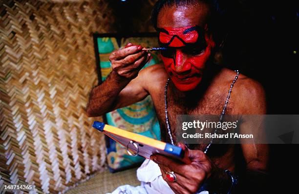 kathakali dancer applying make-up before performance. - kathakali dancing stock-fotos und bilder