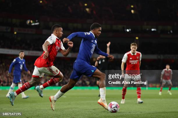 Wesley Fofana of Chelsea runs with the ball whilst under pressure from Gabriel Jesus of Arsenal during the Premier League match between Arsenal FC...