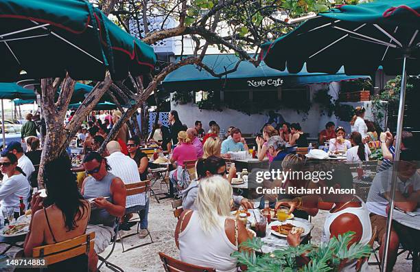 lunch time patrons at news caft on ocean drive at south beach. - caft stock pictures, royalty-free photos & images