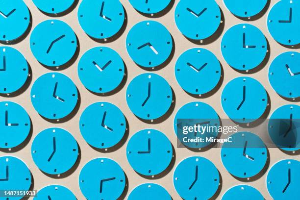 many blue clocks as time symbol paper craft - zona horaria fotografías e imágenes de stock
