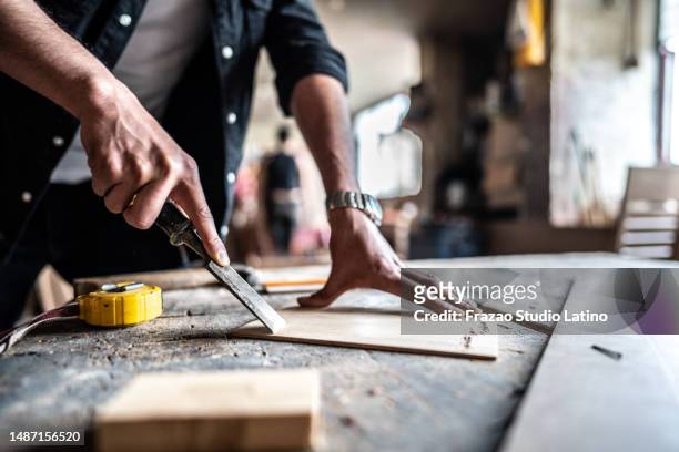 close-up of a man carving wood with chisel and hammer at carpentry - restoring art stock pictures, royalty-free photos & images
