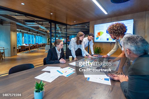 Paperwork and group of peoples hands on a board room table at a business presentation or seminar.