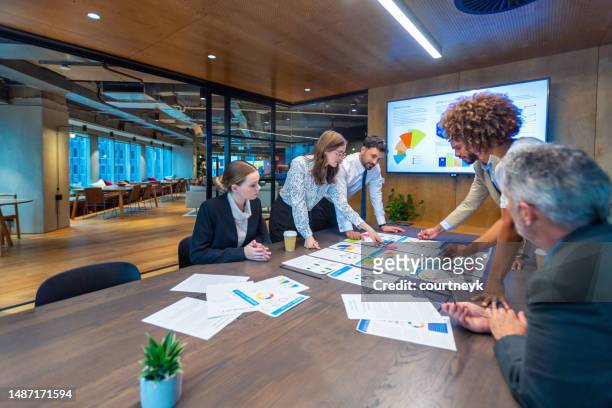 paperwork and group of peoples hands on a board room table at a business presentation or seminar. - market risk stock pictures, royalty-free photos & images