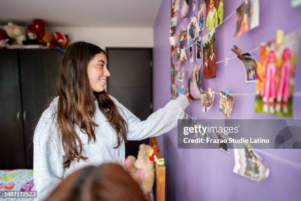 young woman looking photos on wall at bedroom - 18 wall stock pictures, royalty-free photos & images