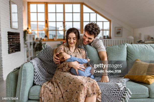 happy young parents cuddling with their cute baby boy - family newborn stock pictures, royalty-free photos & images