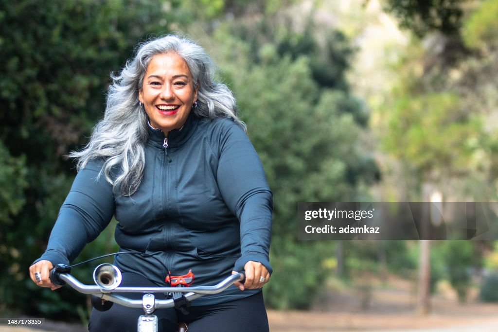 Senior Mexican Frau reiten Fahrrad