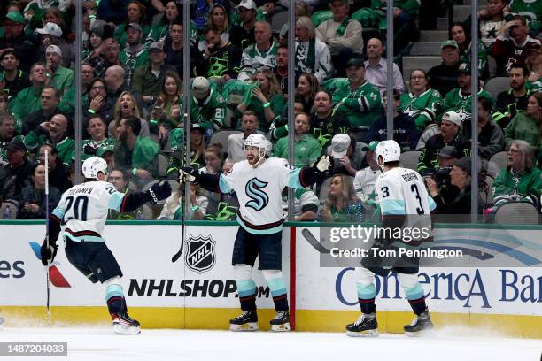 Oliver Bjorkstrand of the Seattle Kraken celebrates with Eeli Tolvanen of the Seattle Kraken and Will Borgen of the Seattle Kraken after scoring a...