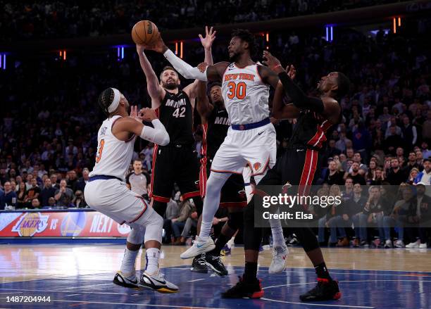 Julius Randle of the New York Knicks passes the rebound as Kevin Love and Bam Adebayo of the Miami Heat defend during game two of the Eastern...
