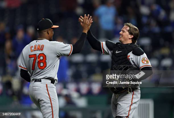 Yennier Cano of the Baltimore Orioles is congratulated by catcher Adley Rutschman after the Orioles defeated the Kansas City Royals 11-7 to win the...