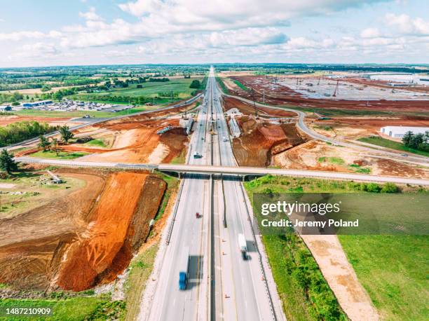 aerial photo of semi trucks passing red dirt work and construction at the interstate 65 exit for glendale, kentucky, usa - construção de estrada imagens e fotografias de stock