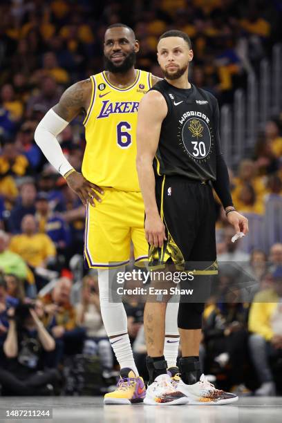 LeBron James of the Los Angeles Lakers stands next to Stephen Curry of the Golden State Warriors during the second quarter in game one of the Western...