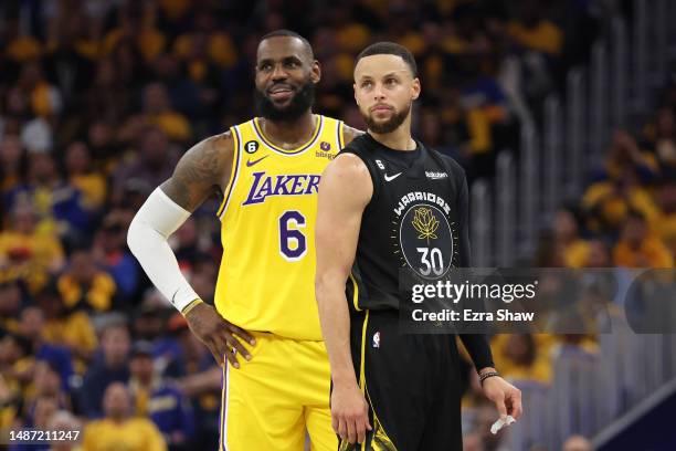 LeBron James of the Los Angeles Lakers stands next to Stephen Curry of the Golden State Warriors during the second quarter in game one of the Western...