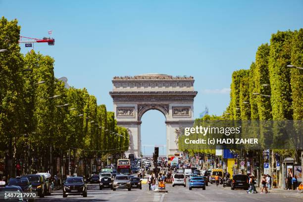 a day view of arc de triomphe de l'étoile on the iconic champs elysees in paris - champs elysees quarter stock pictures, royalty-free photos & images