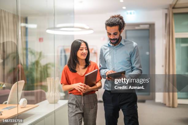 vielfältige kolleginnen und kollegen, die gemeinsam an digitalen tablets arbeiten - employees diversity stock-fotos und bilder