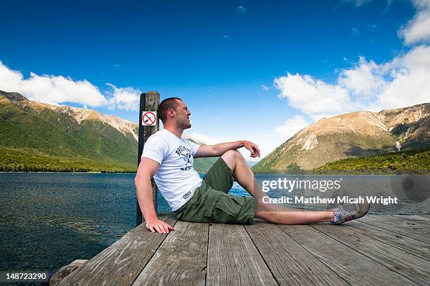 lake rotoiti is lake in the tasman region of new zealand. it is a mountain lake within in the nelson lakes national park. relaxing on the end of the  pier on this sunny afternoon - nelson lakes national park stock pictures, royalty-free photos & images