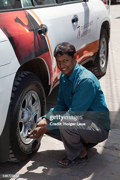 man reducing tyre pressure on 4wd vehicle in preparation for a sand dune tour in wahiba sands desert. - tire car middle east stock pictures, royalty-free photos & images