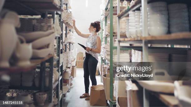 businesswoman with digital tablet checking the stock in ceramic factory warehouse - small business stock pictures, royalty-free photos & images