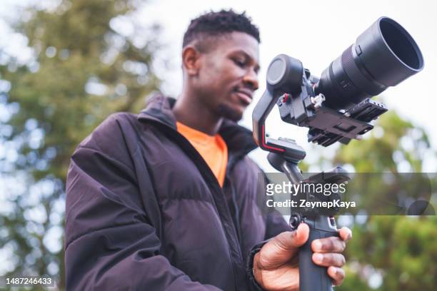cameraman filming with gimbal - young film director stock pictures, royalty-free photos & images
