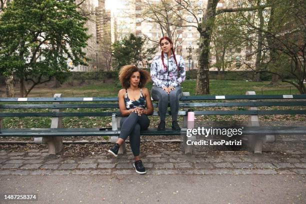 portrait of two athletic women in a park - bench stock pictures, royalty-free photos & images