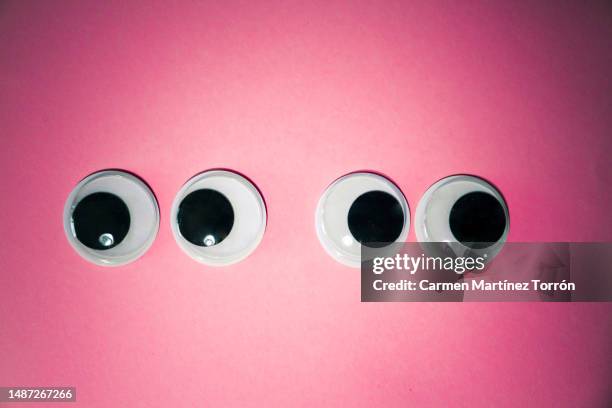 googly eyes on pink background. anger in the couple concept. - staring at screen stock pictures, royalty-free photos & images