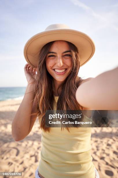 happy woman taking a selfie outdoors during her beach holiday. - beach selfie bildbanksfoton och bilder