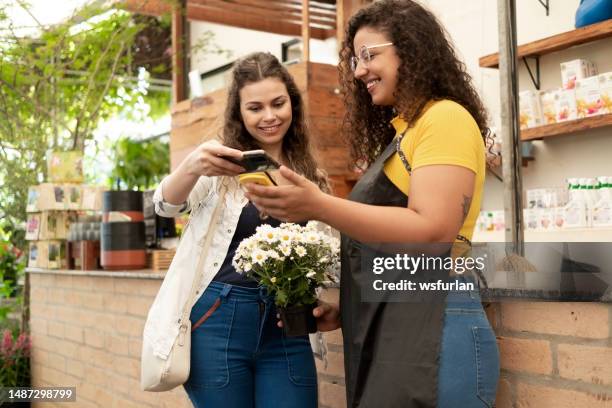 owner and client in a flower shop - phone payment stock pictures, royalty-free photos & images