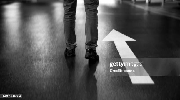 businessman walking along white direction arrow - arrow sign stock pictures, royalty-free photos & images