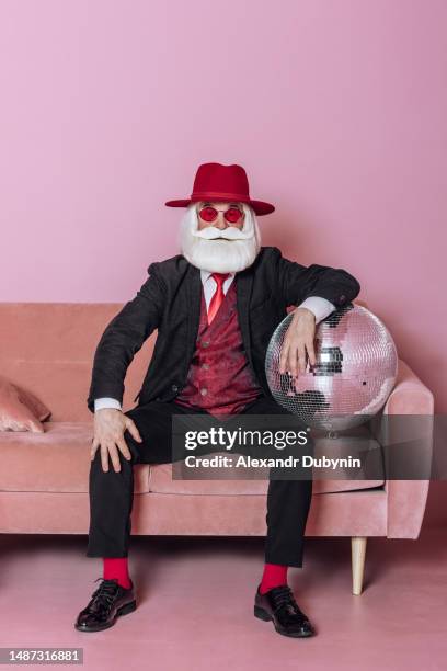 old hipster man sitting on a pink sofa. fashion concept - crazy holiday models stock pictures, royalty-free photos & images