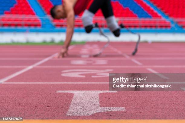 disabled man athlete ready for training with leg prosthesis athletics track in stadium. - paralympics track stock pictures, royalty-free photos & images