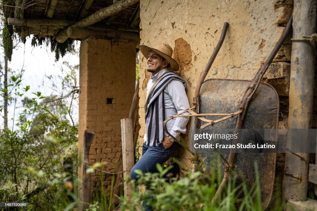 Joven agricultor mirando hacia otro lado relajándose en la granja