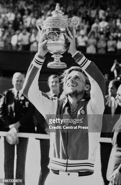 Tennis player Bjorn Borg holds the winner's trophy above his head after winning the Wimbledon men's singles final against John McEnroe at the All...