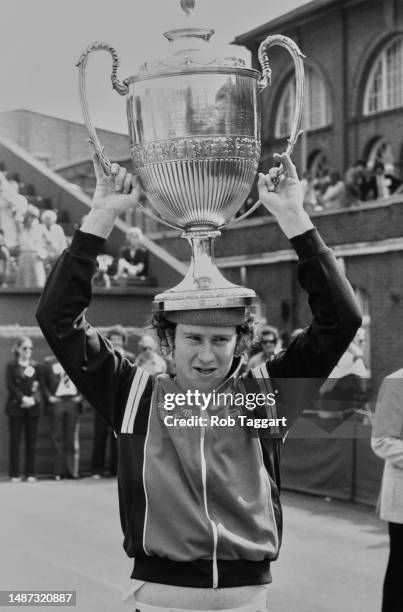 Tennis player John McEnroe holds the winner's trophy on top of his head after defeating Victor Pecci in the men's singles final of the Stella Artois...