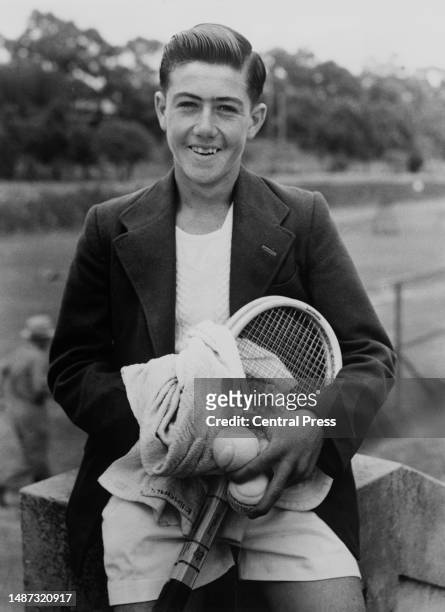 Teenage Australian tennis player Ken Rosewall holding tennis balls and tennis rackets, 1951.