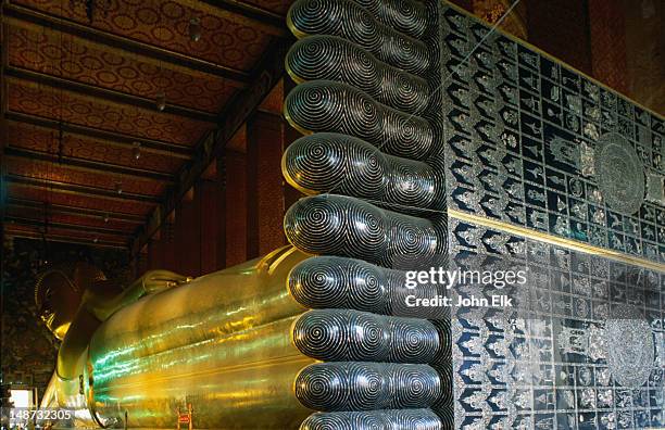 oblique detail view of reclining buddha and his feet in wat pho. - reclining buddha stock-fotos und bilder