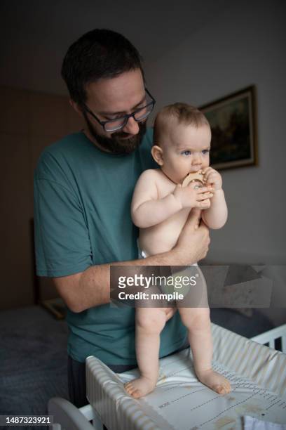 padre che si prende cura del suo bambino - adult baby boy diaper change foto e immagini stock