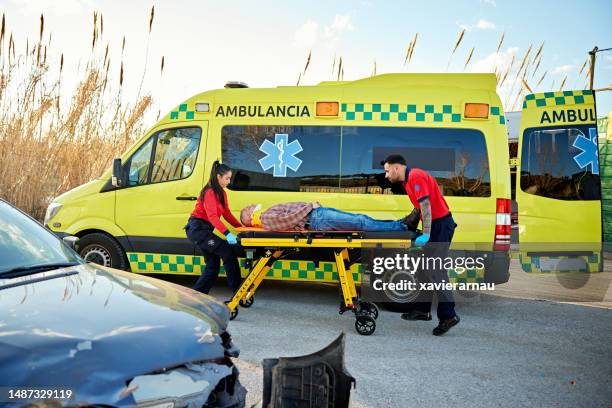 paramedics transferring victim from crash site to ambulance - emergency equipment 個照片及圖片檔