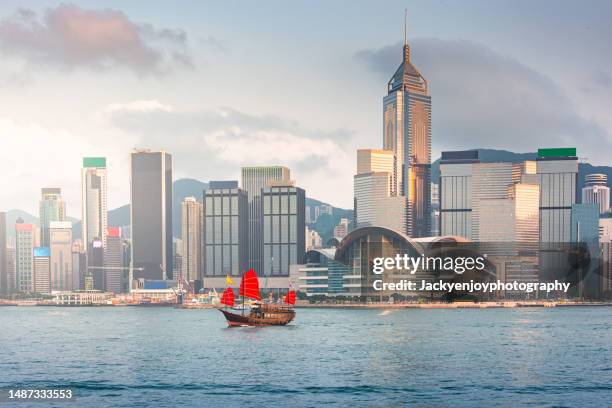 junk boat in victoria harbour - isla de hong kong fotografías e imágenes de stock