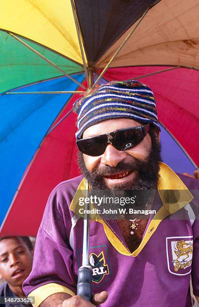 portrait of man holding umbrella, market place. - papua new guinea market stock pictures, royalty-free photos & images