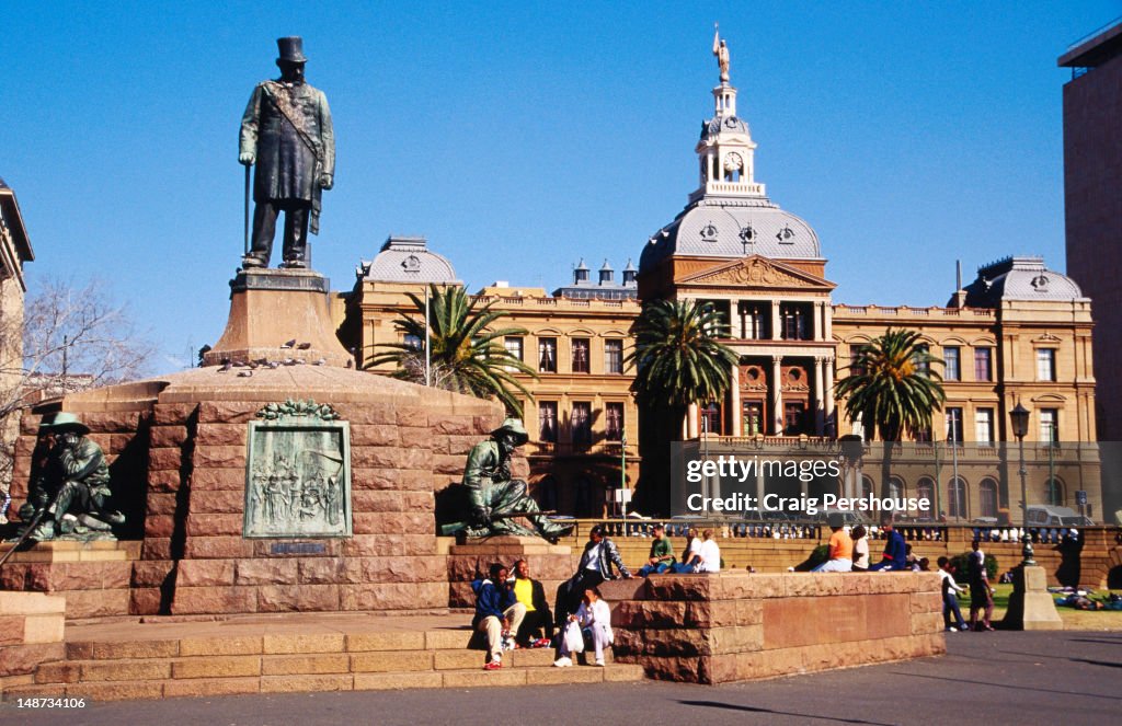 Statue of Paul Kruger with voortrekkers in Church Square with Ou Raadsaal in background.