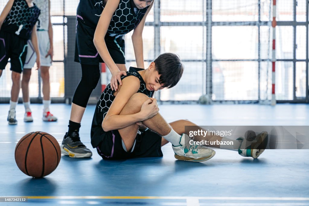 Injuring Teenage Boy Injuring His Knee While Playing Basketball Indoors High-Res ...