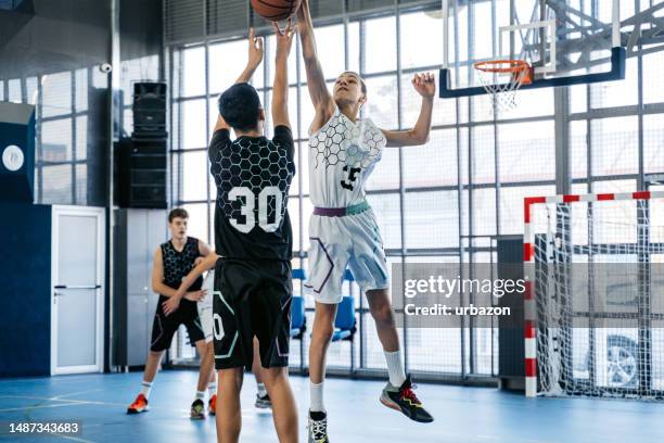 teenagers playing basketball indoors - high school basketball stock pictures, royalty-free photos & images