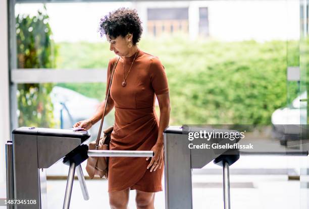 young businesswoman entering her office building using a cardkey - torniquete imagens e fotografias de stock