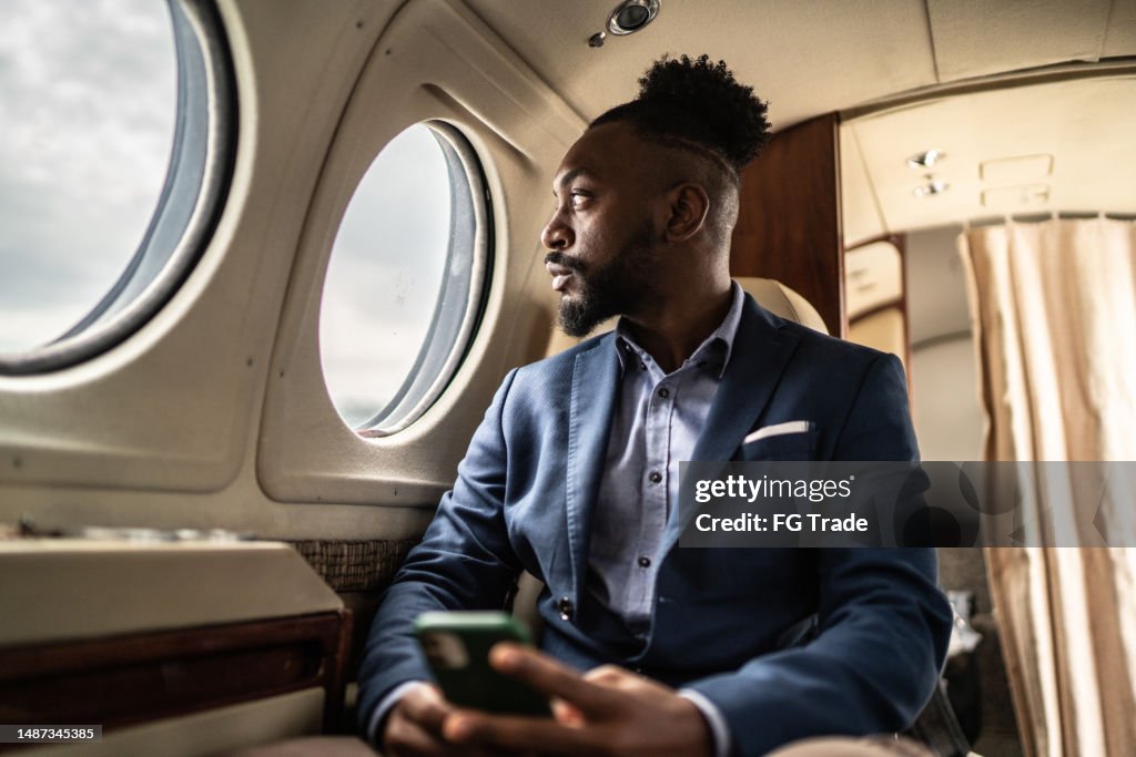 Mid adult businessman contemplating on a private jet