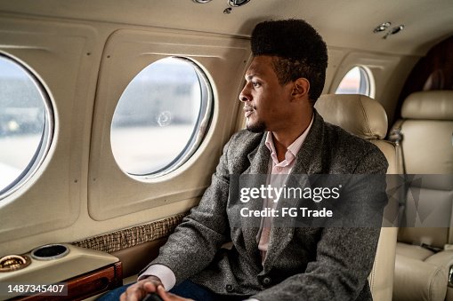 Mid adult man contemplating on a private jet Mid adult man contemplating on a private jet