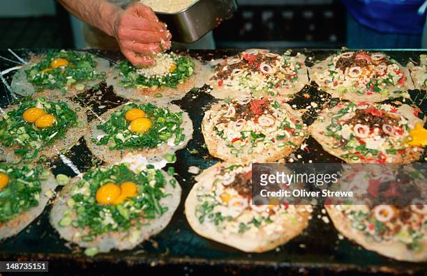 preparing okonomiyaki, or japanese pizza. - okonomiyaki 個照片及圖片檔