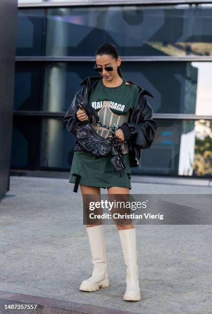 Guest is seen wearing green ripped Balenicaga shirt, black leather jacket, bag, boots at VISA Fashion Week Almaty Season VII on May 03, 2023 in...